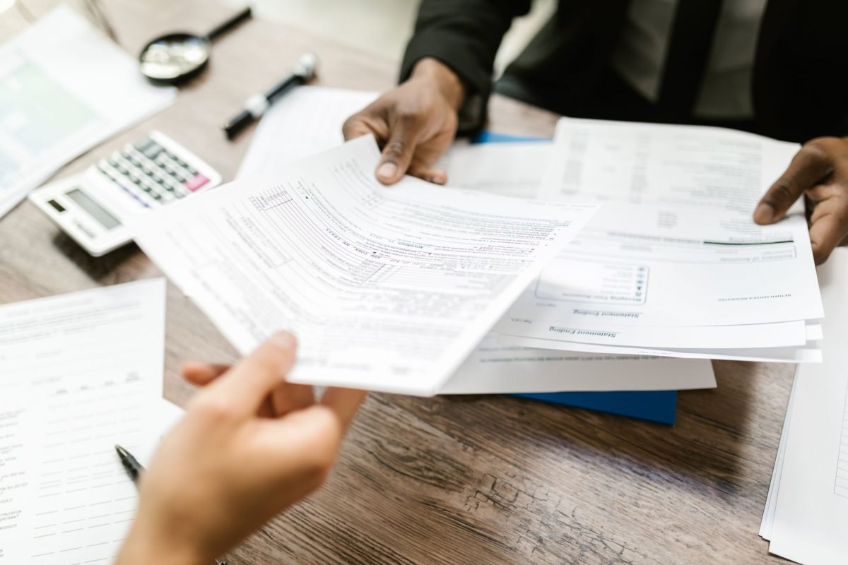 Two professionals exchanging documents in an office
