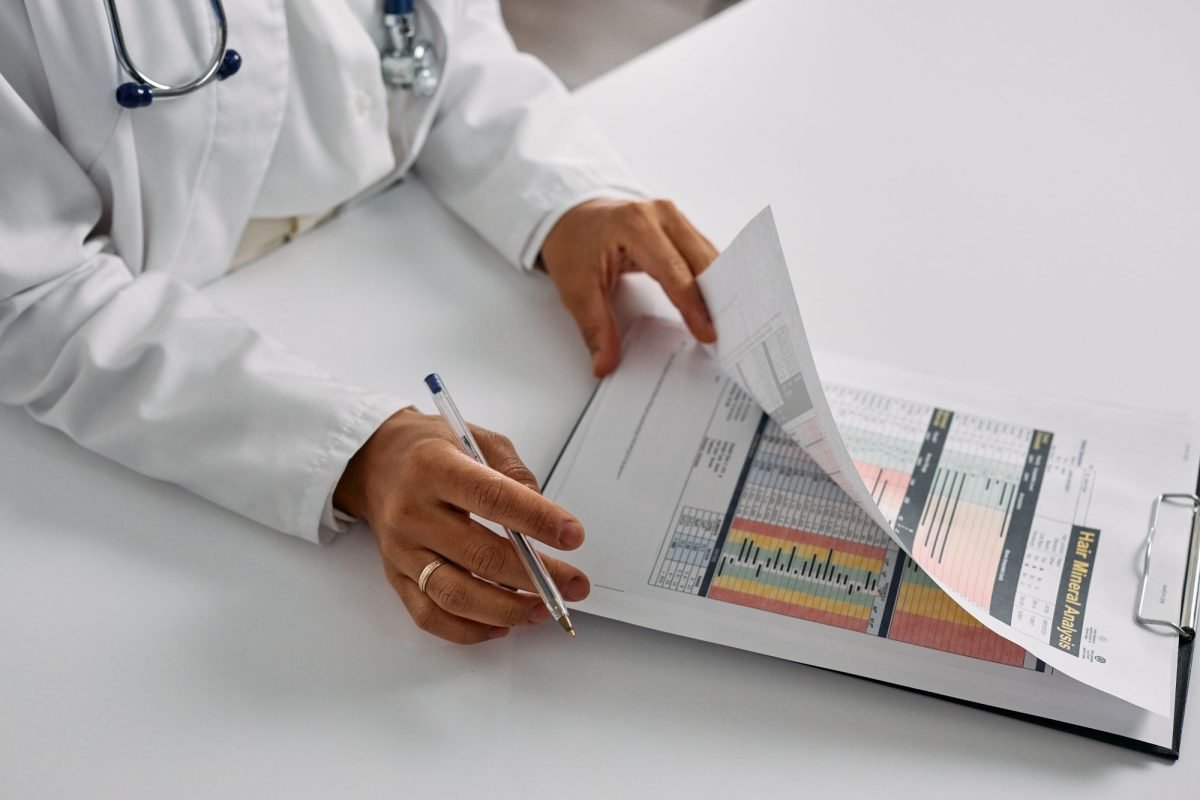 A medical professional checking patient reports on a clipboard