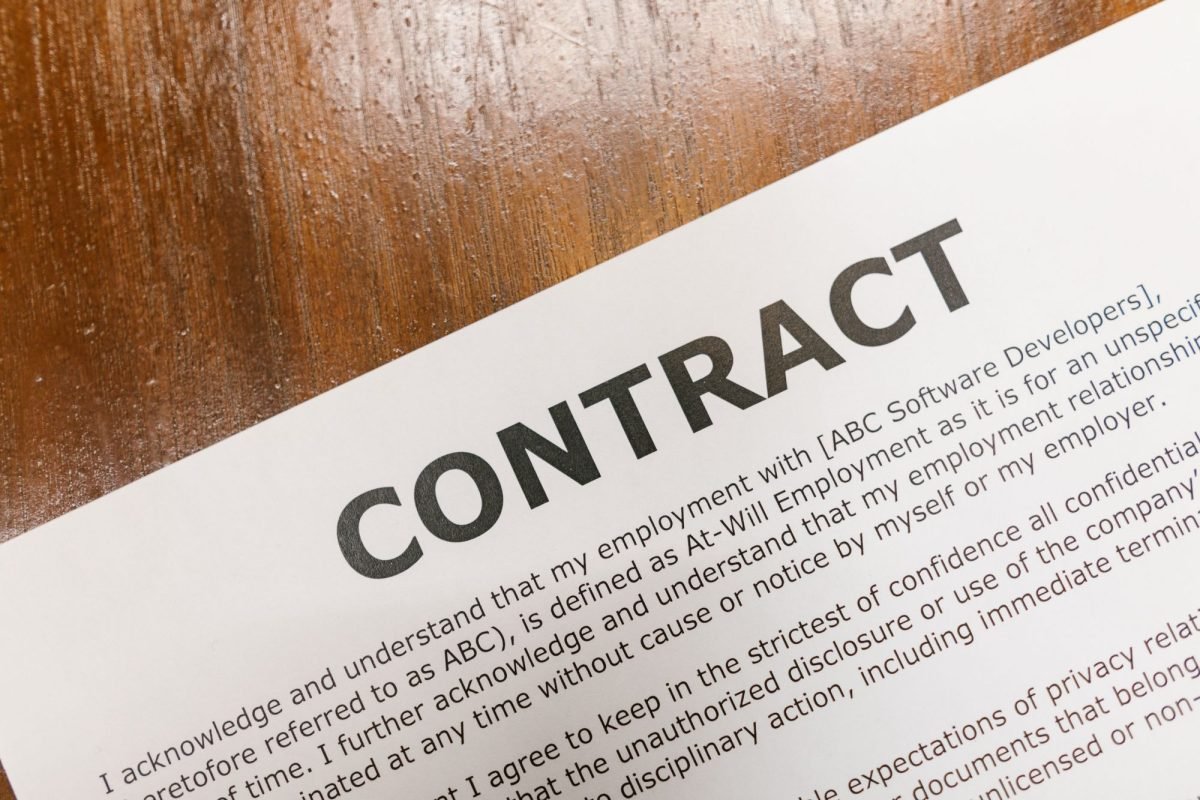 A printed contract on a wooden table