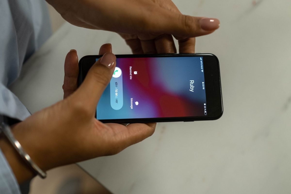Hands holding a smartphone displaying an incoming call
