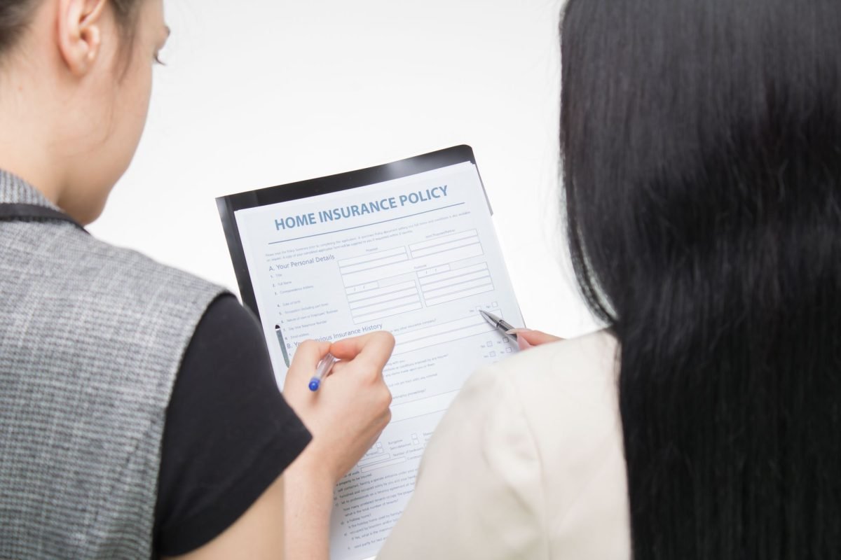 Two people examining a home insurance policy form