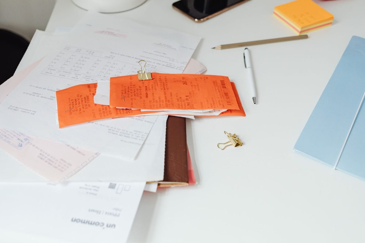 Receipts and documents arranged on a tidy desk with stationery