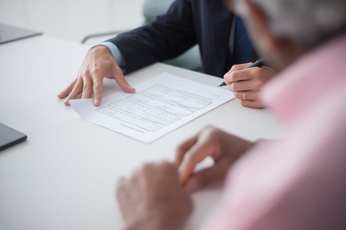 Two professionals signing documents at a meeting