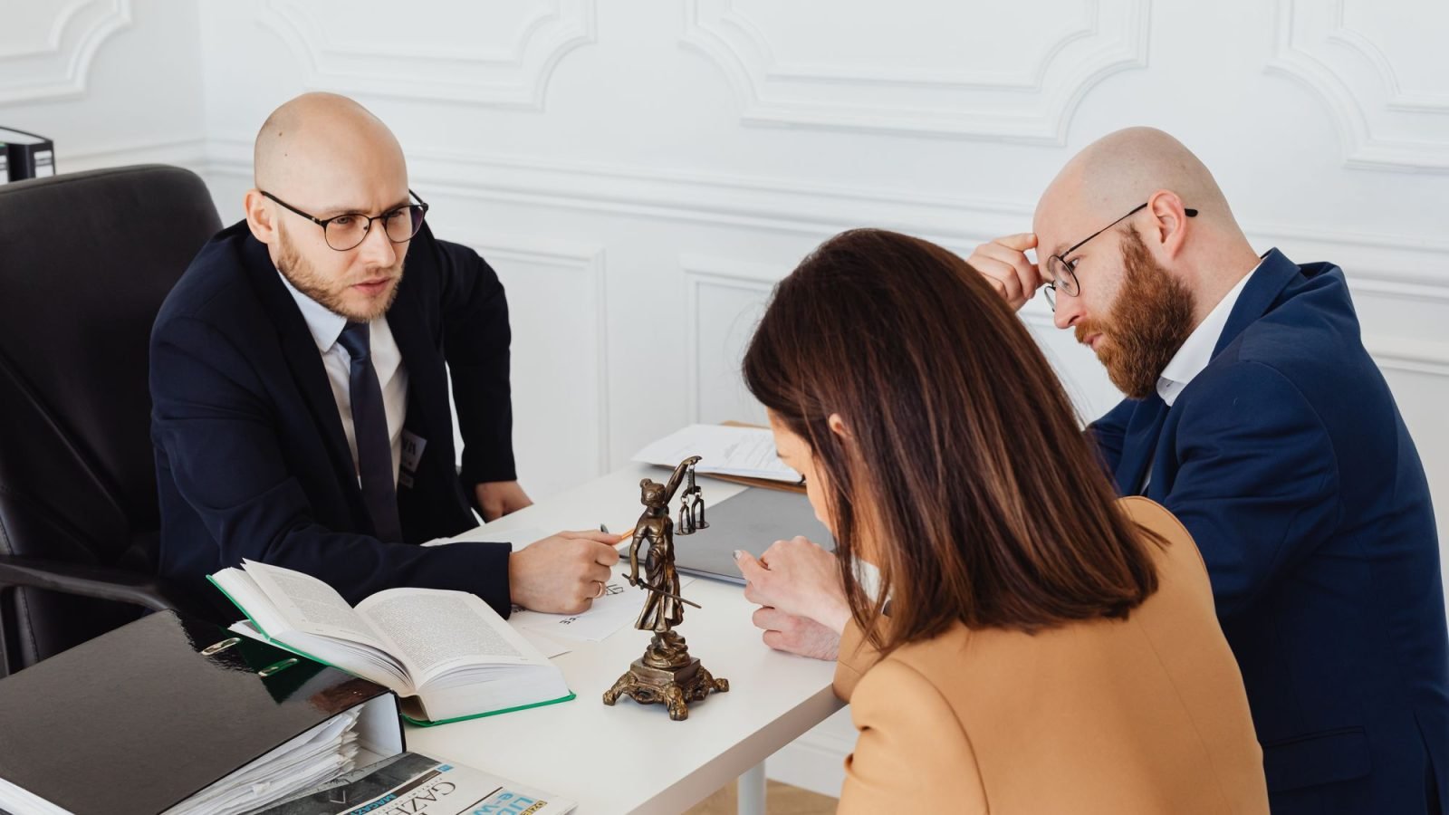 A lawyer talking with a couple in a modern office