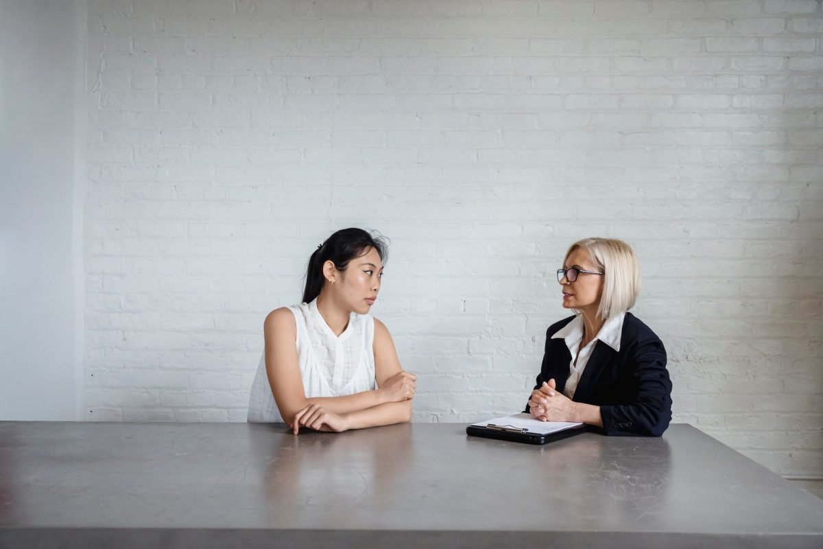 Two women talking in a white office