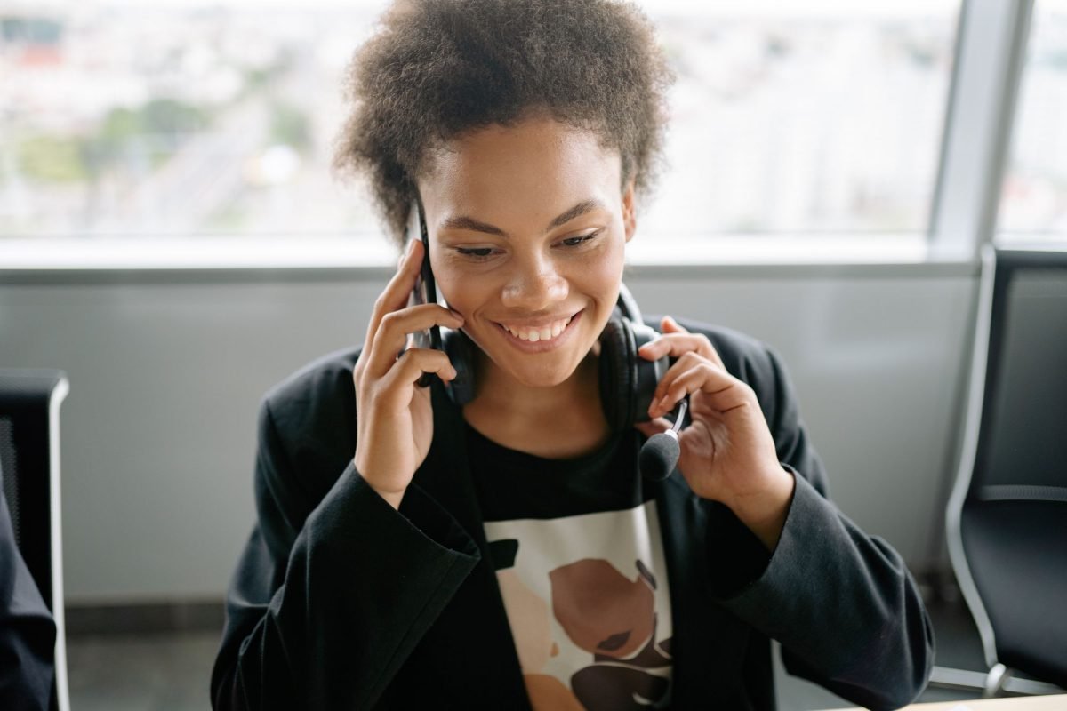 A woman with a headset holding a phone