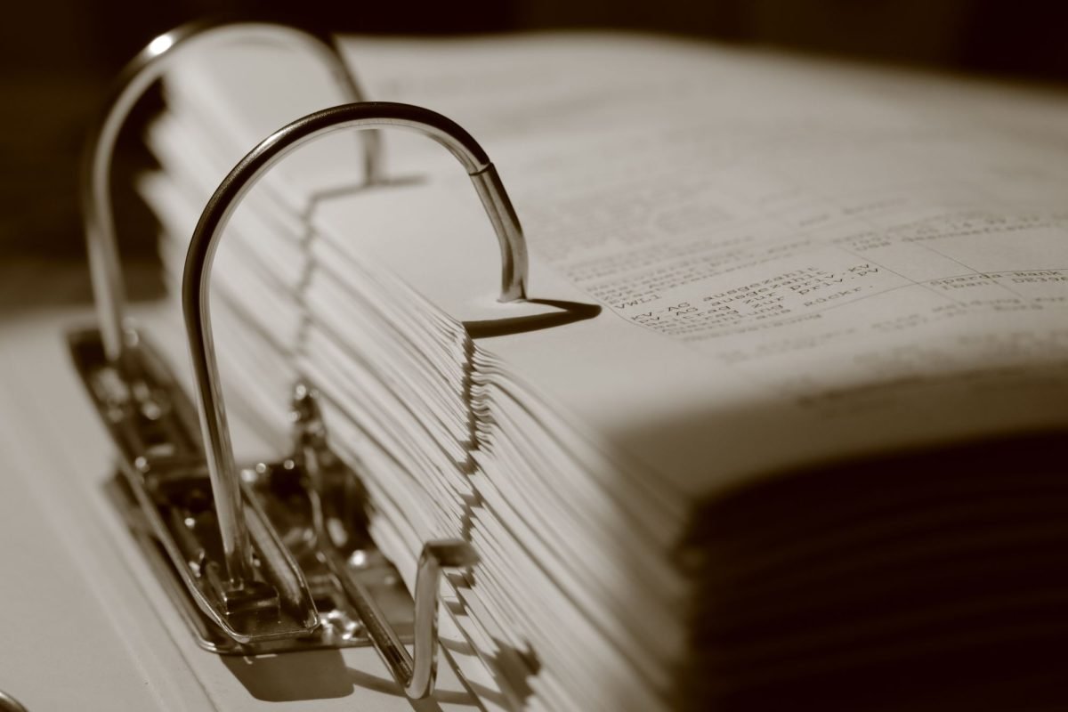 Close-up of a binder filled with documents in sepia tone