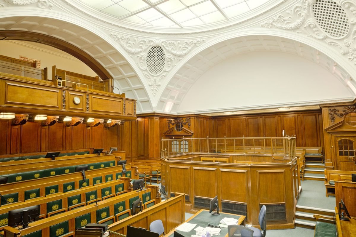 Interior of a historic courtroom in London with ornate wooden furnishing