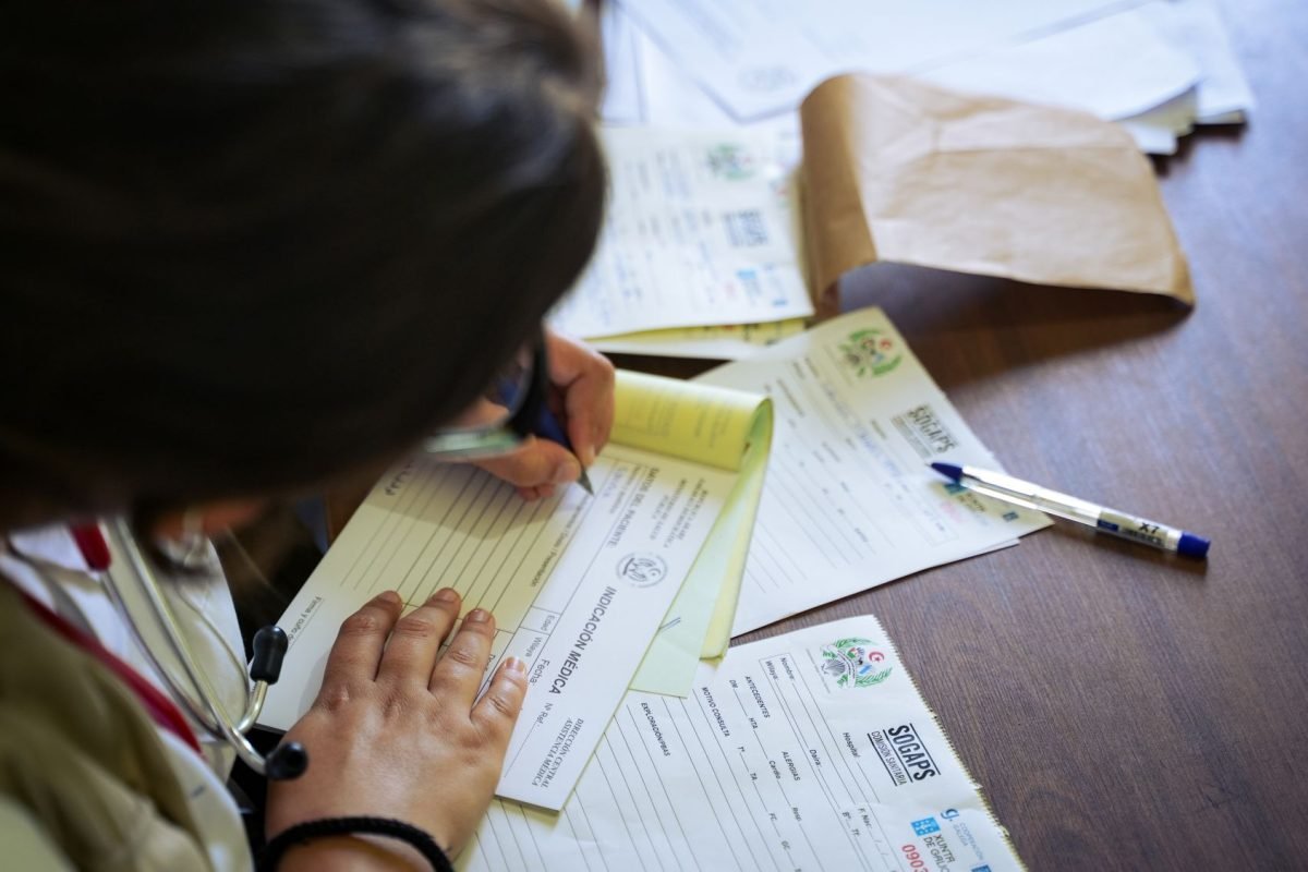 A doctor filling out medical forms indoors