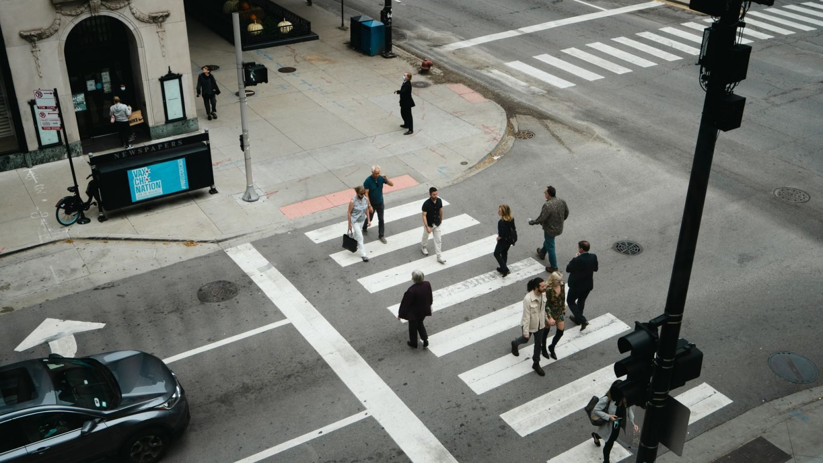 Aerial view of people crossing a city street at a pedestrian crosswalk