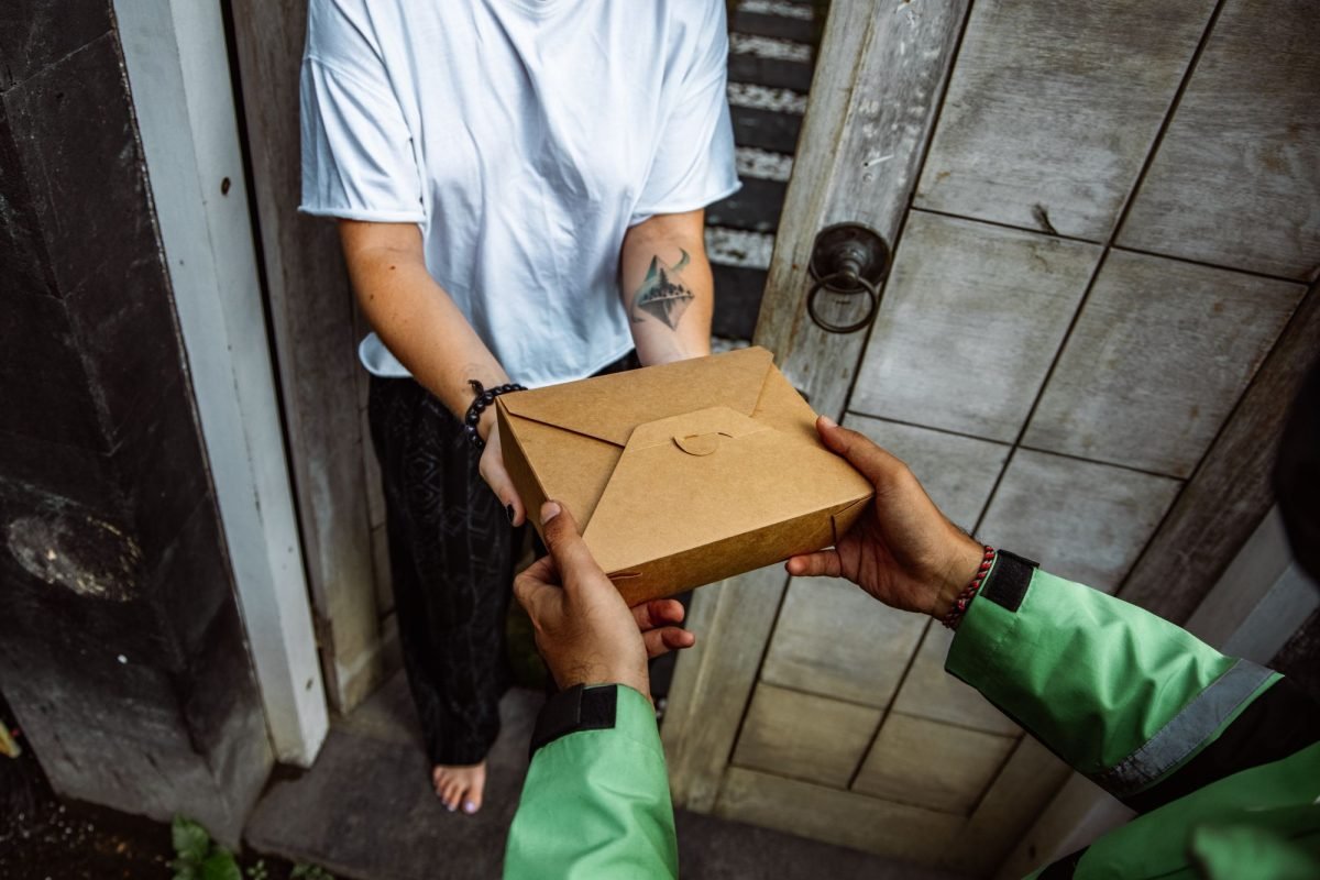 A delivery person handing a package to a customer at the door