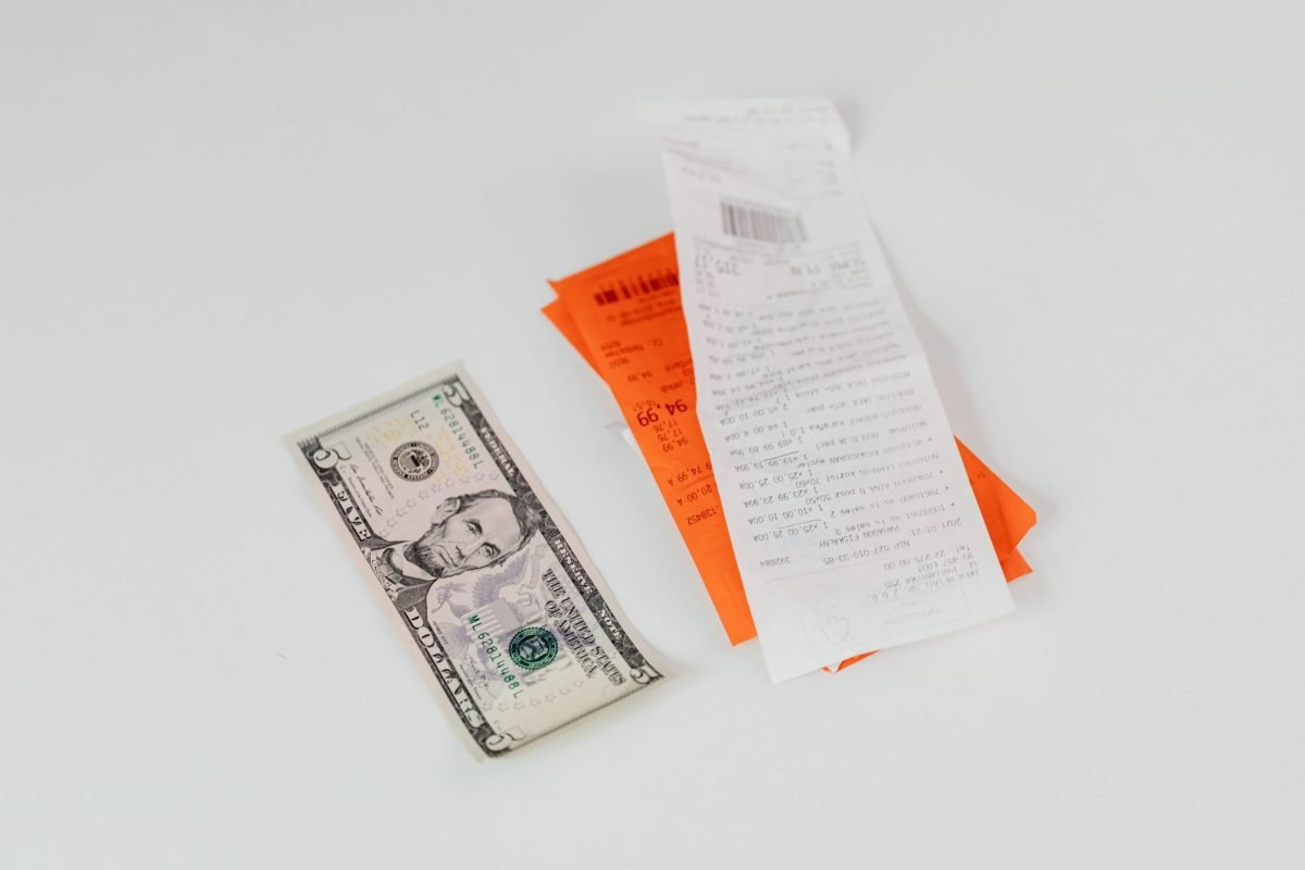 A five-dollar bill beside shopping receipts