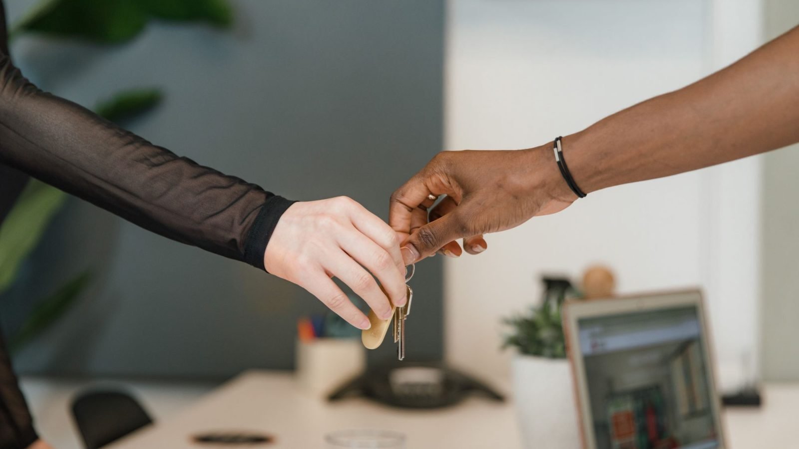 Hands exchanging keys in an office