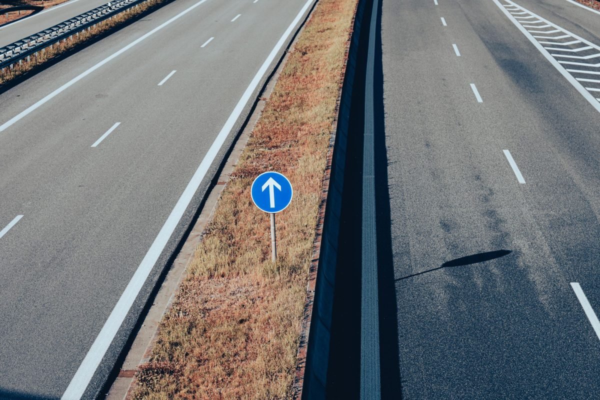 Aerial view of an empty highway with a traffic sign and arrow