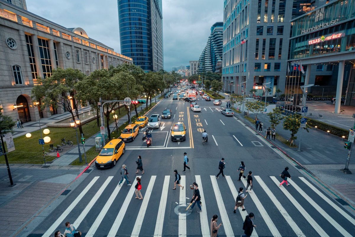 High-angle view of a city street with pedestrians crossing and evening traffic