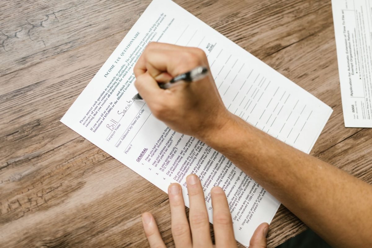 A person filling out a questionnaire with a pen