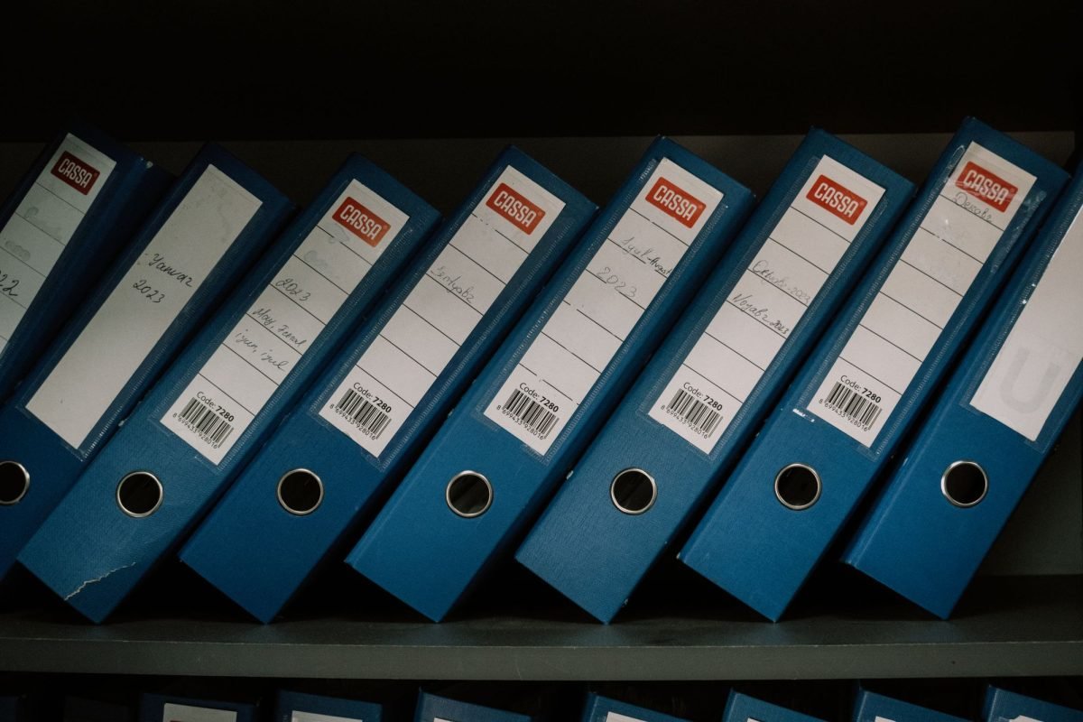 Neatly arranged blue binders labeled with dates and names