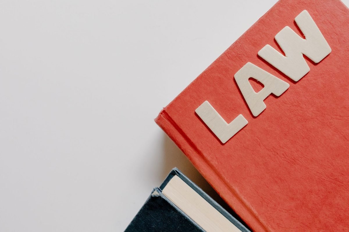 A red law textbook and a dark book on a white background