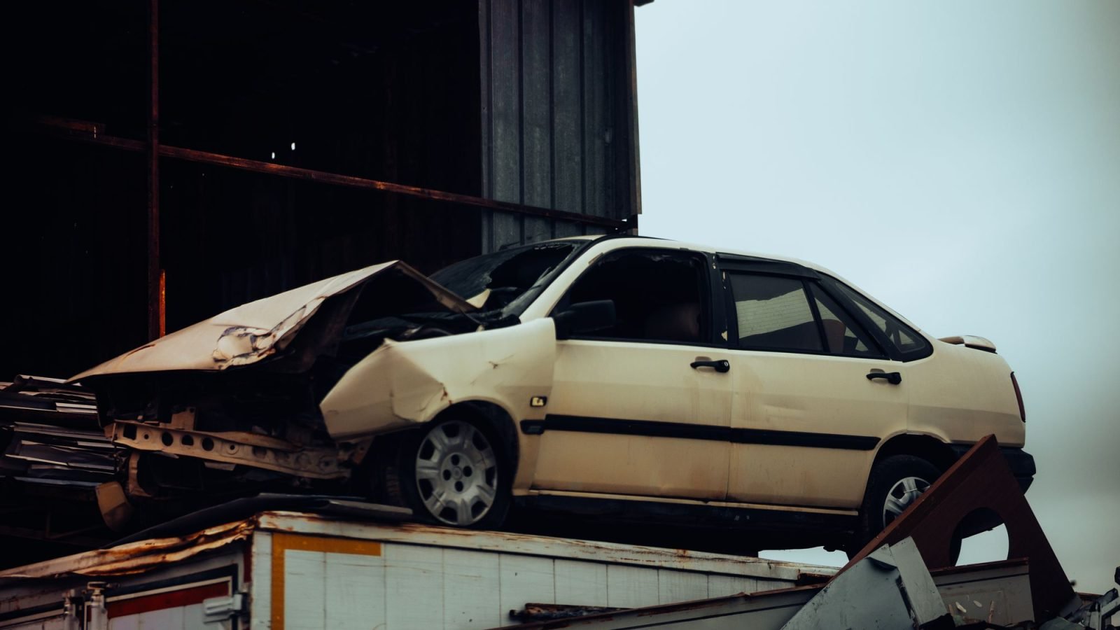 A damaged car on top of a metal scrap heap