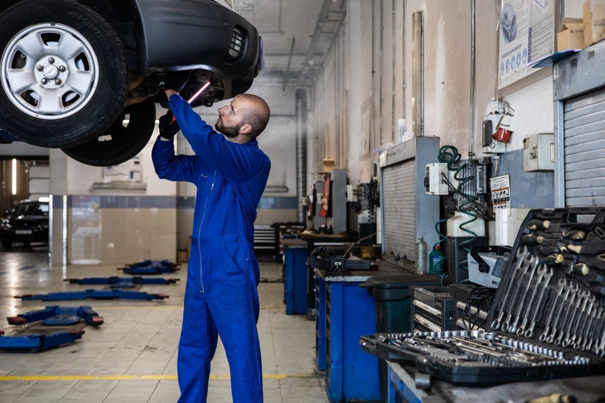 A man in a blue suit checking a car