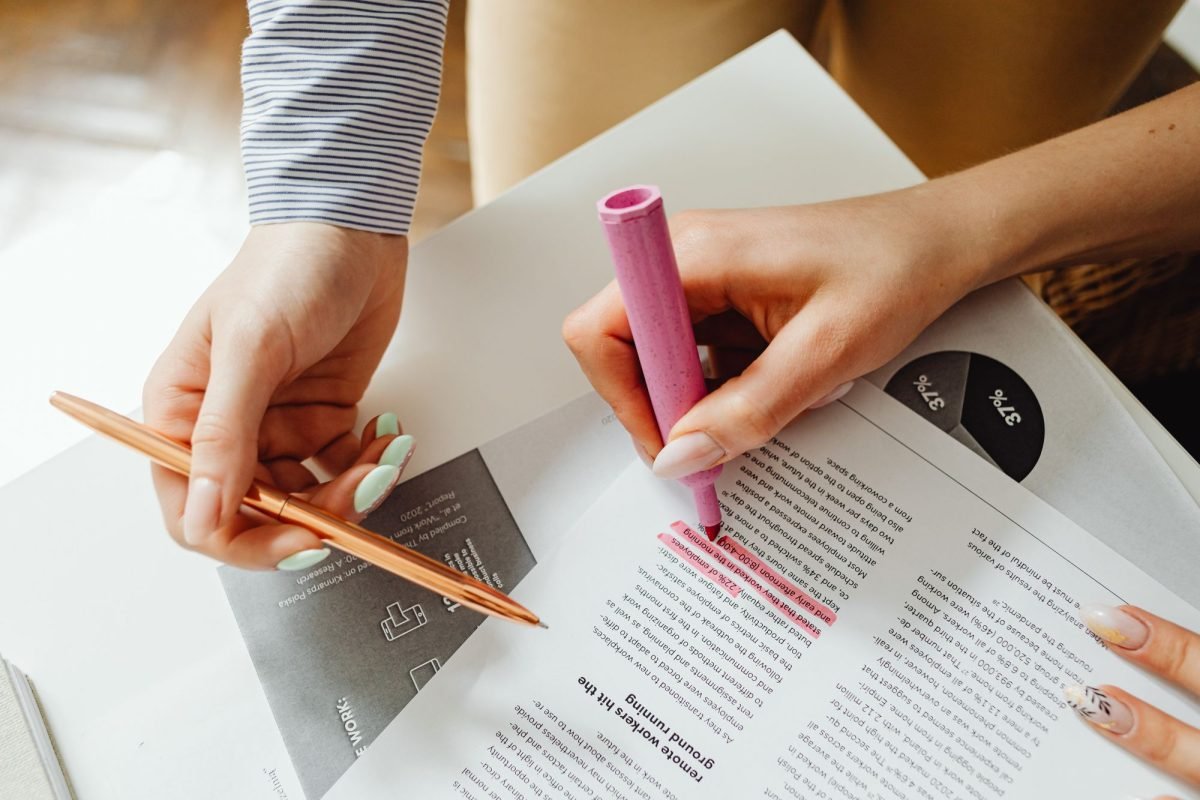 Hands highlighting a document and taking notes