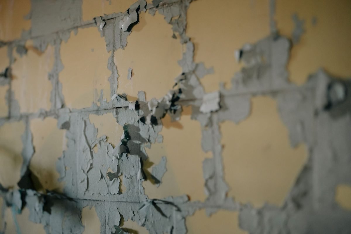 Close-up of aged, peeling paint on a weathered wall
