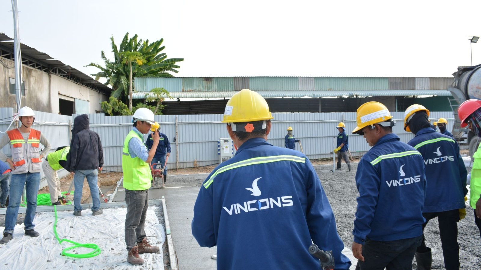 Construction workers wearing hard hats assessing a site outdoors