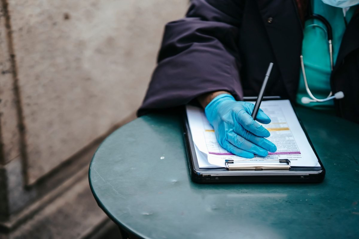 A physician with a clipboard at a table
